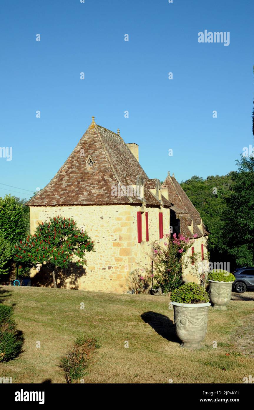A fine example of a country house in the Perigord Noir region of the Dordogne. It is built of honey coloured stone with a steeply pitched roof. Stock Photo