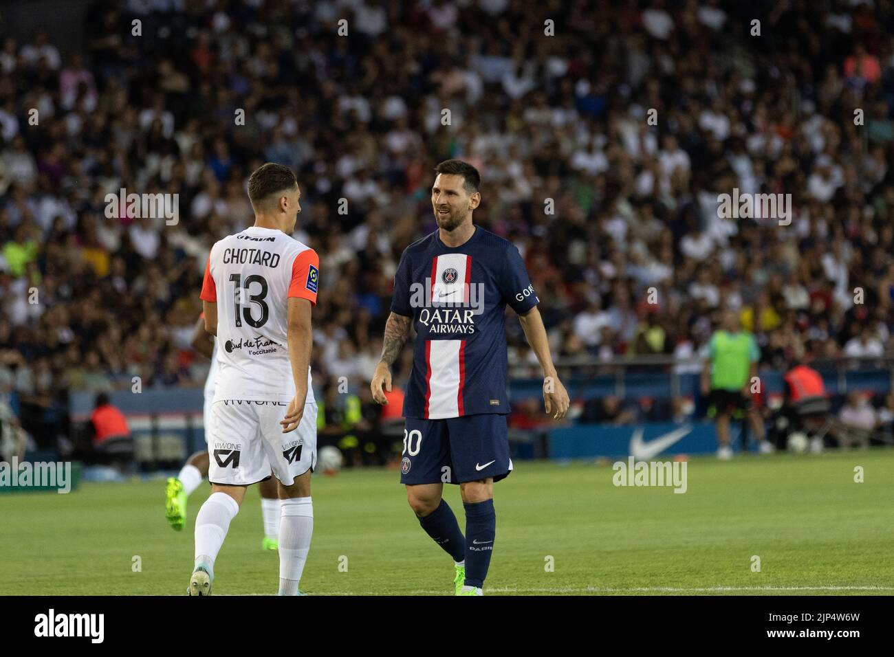 The player Lionel Messi facing another player from Montpellier Stock Photo