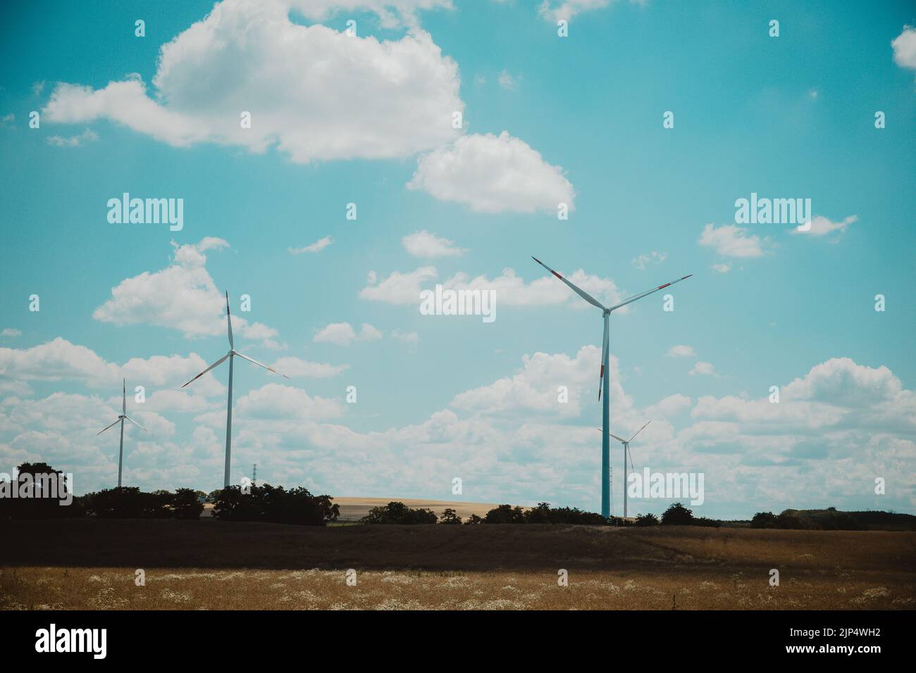 A wind power plant with turbines under a blue sky with clouds Stock ...