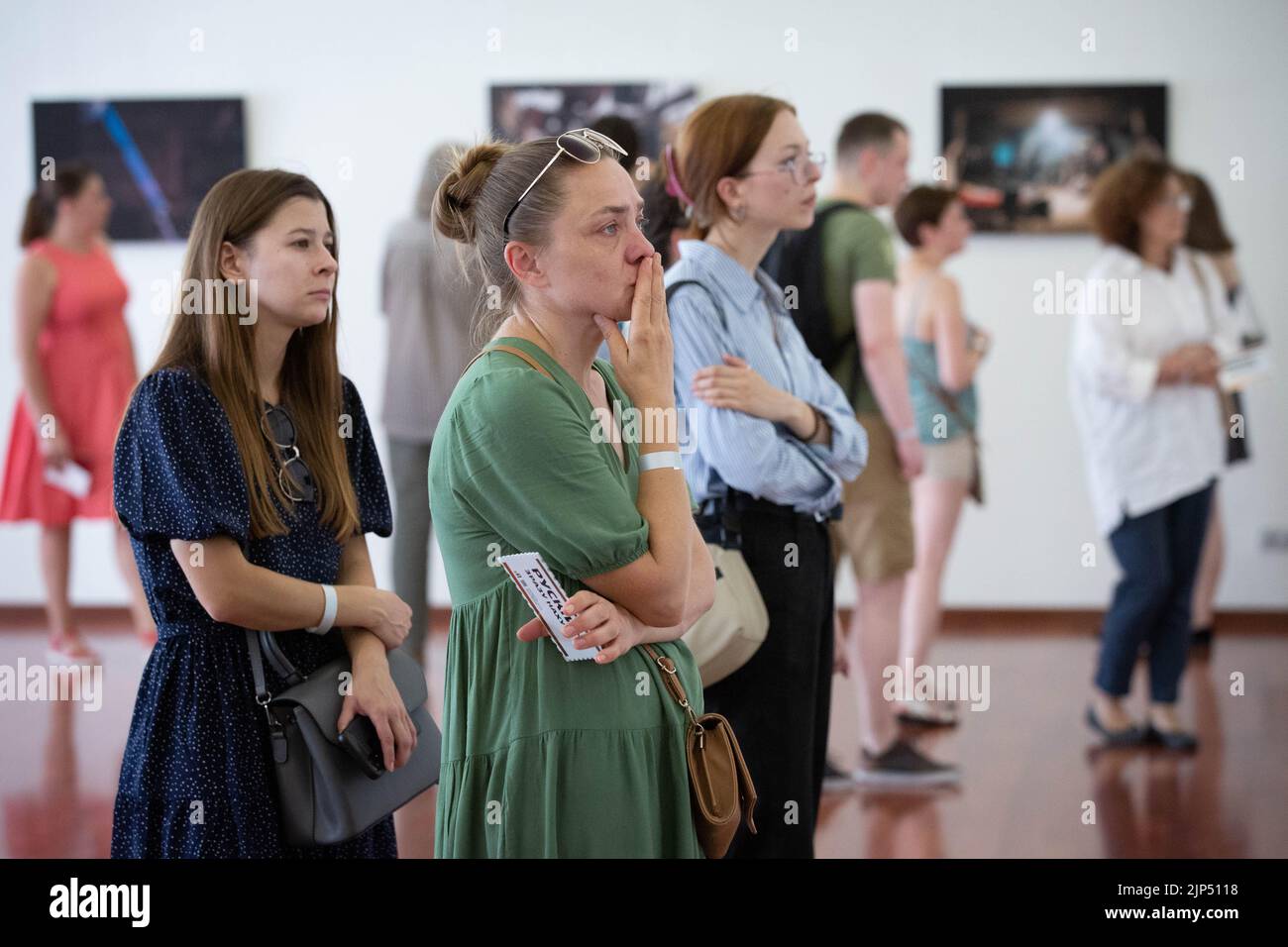 Kyiv, Ukraine. 14th Aug, 2022. People watch pictures by Azov soldier-photographer Dmytro 'Orest' Kozatsky shown at exhibition titled "Unprecedented Azovstal" in Kyiv. Photographies by Dmytro 'Orest' Kozatsky show the realities of Azov regiment soldiers sieged at Azovstal steel plant in Mariupol. Before being captured Kozatsky published his pictures on social networks in order to spread them as widely as possible. Credit: SOPA Images Limited/Alamy Live News Stock Photo