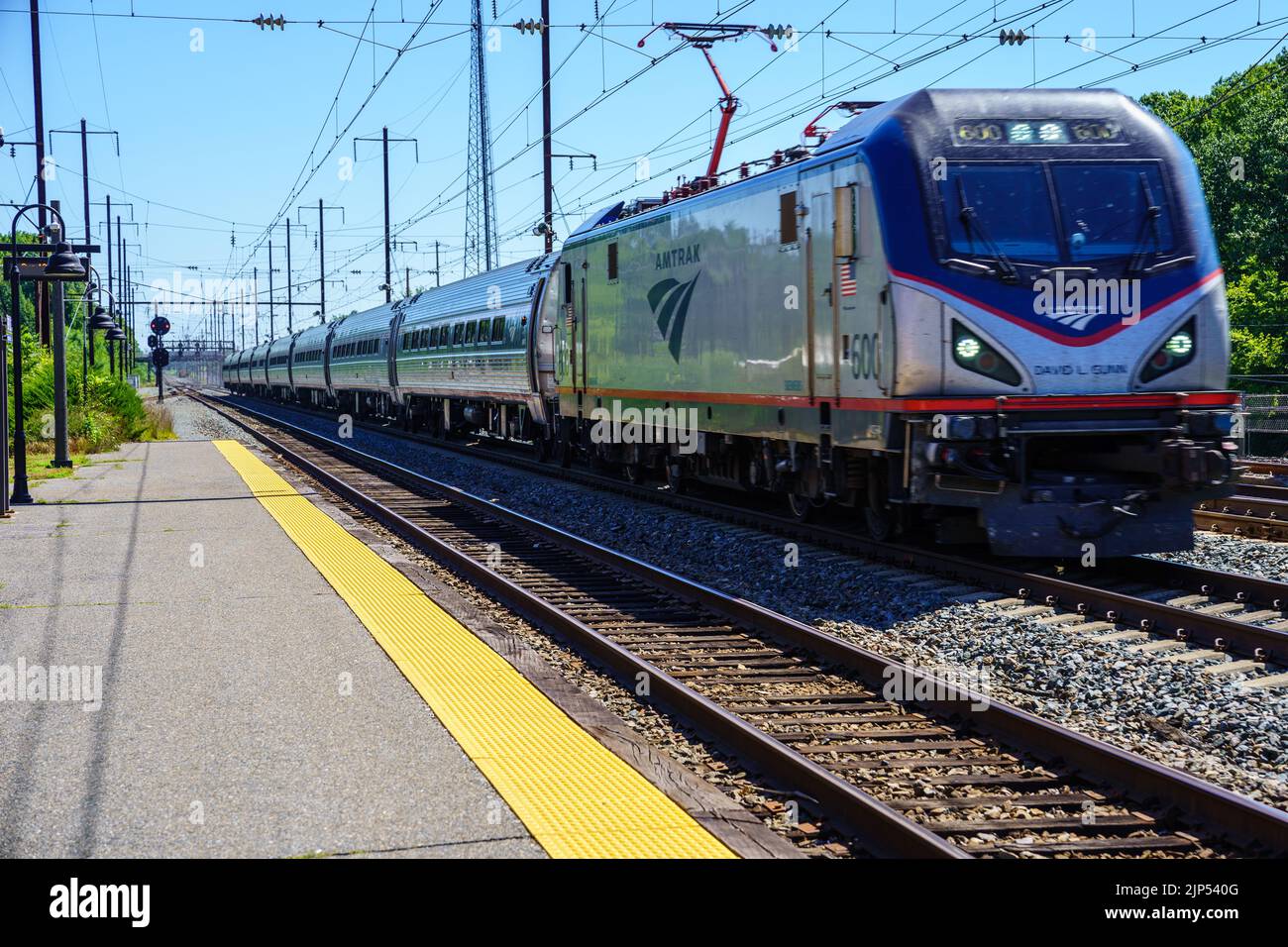 Perryville, MD, USA – August 13, 2022: An Amtrak passenger train traveling through a small Maryland town about to cross over the Susquehanna River. Stock Photo