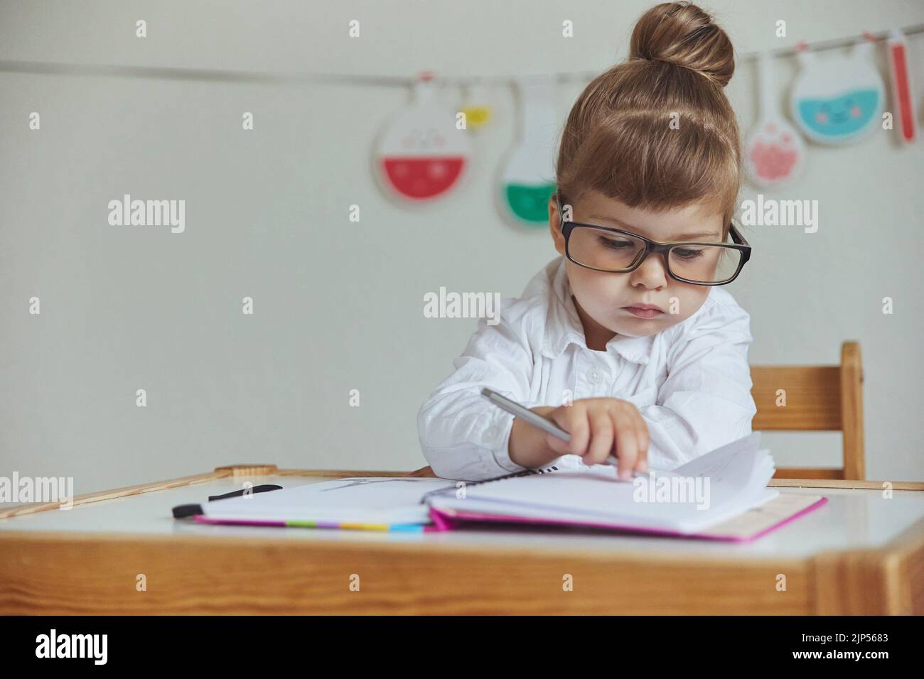 Charming child plays pretending to be a teacher Stock Photo