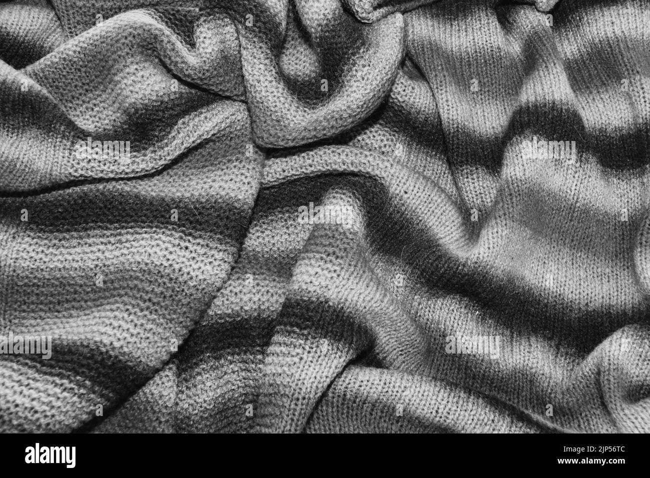 Black and white background of a knitted textile material. Fabric with a striped texture closeup. Stock Photo