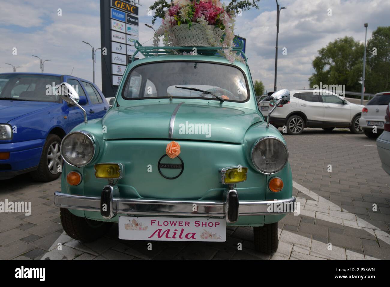 The legendary car supermini Zastava 750 (Fiat 600) which was produced from 1955 to 1985 parked in the front of the flower shop, decorated with flowers Stock Photo