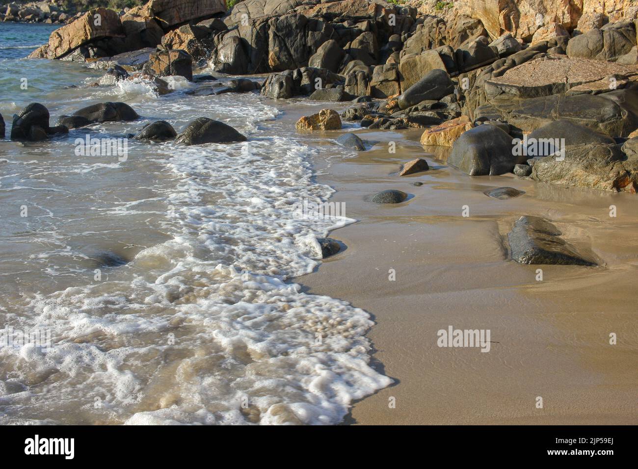 waves with plenty of foam reach the rocky beach Stock Photo - Alamy