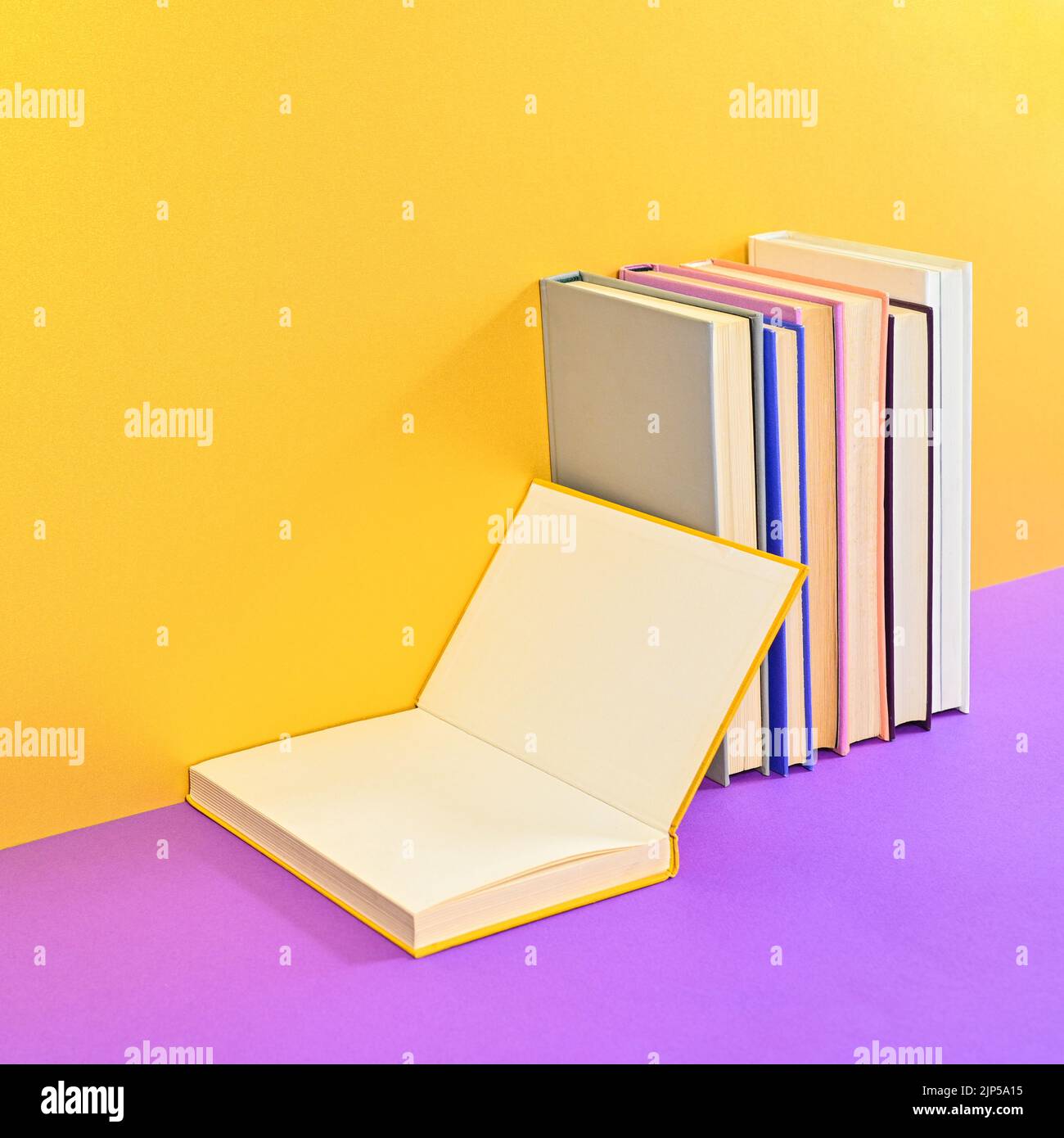 Creative composition of hardcover books with open book copy space on