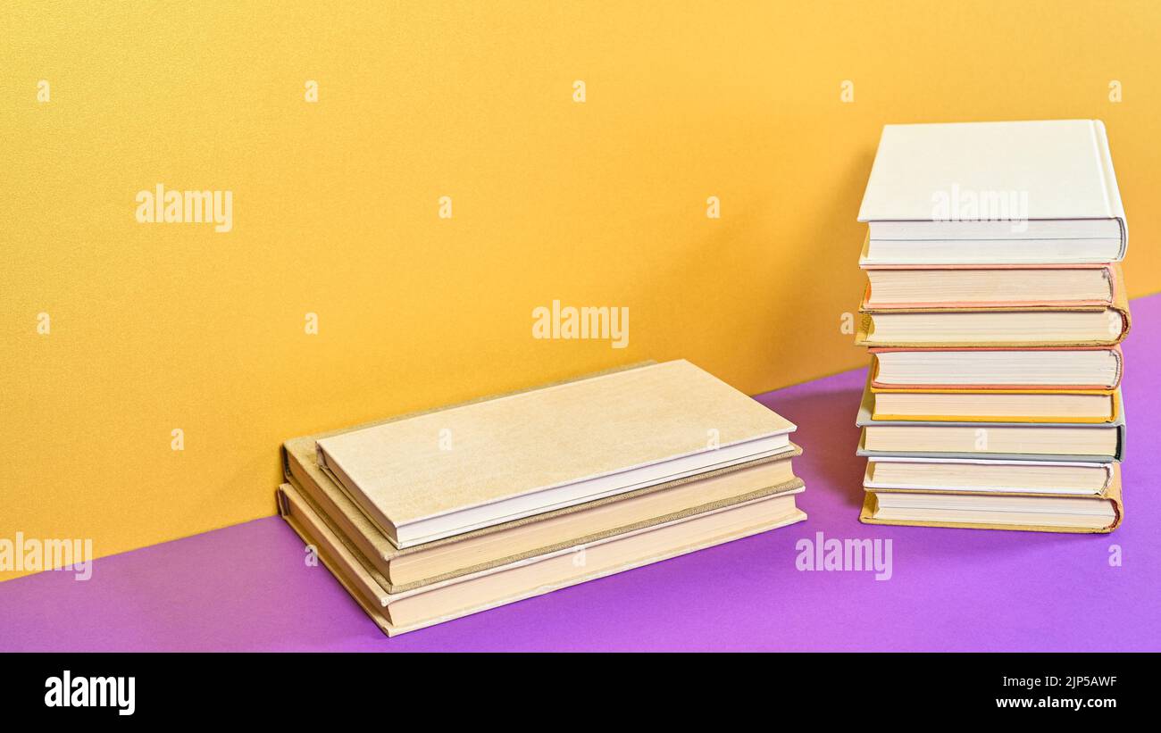 Golden purple background with hardcover books and copy space. Flat lay