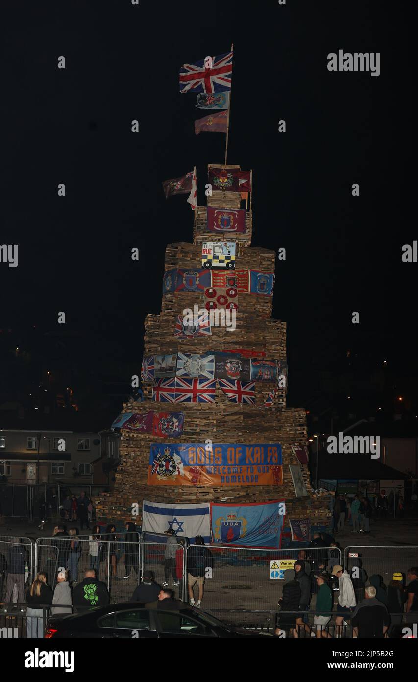 People start to gather for the lighting of a bonfire stack to mark the Catholic Feast of the Assumption in the Bogside area of Londonderry, Northern Ireland. Picture date: Monday August 15, 2022. Stock Photo