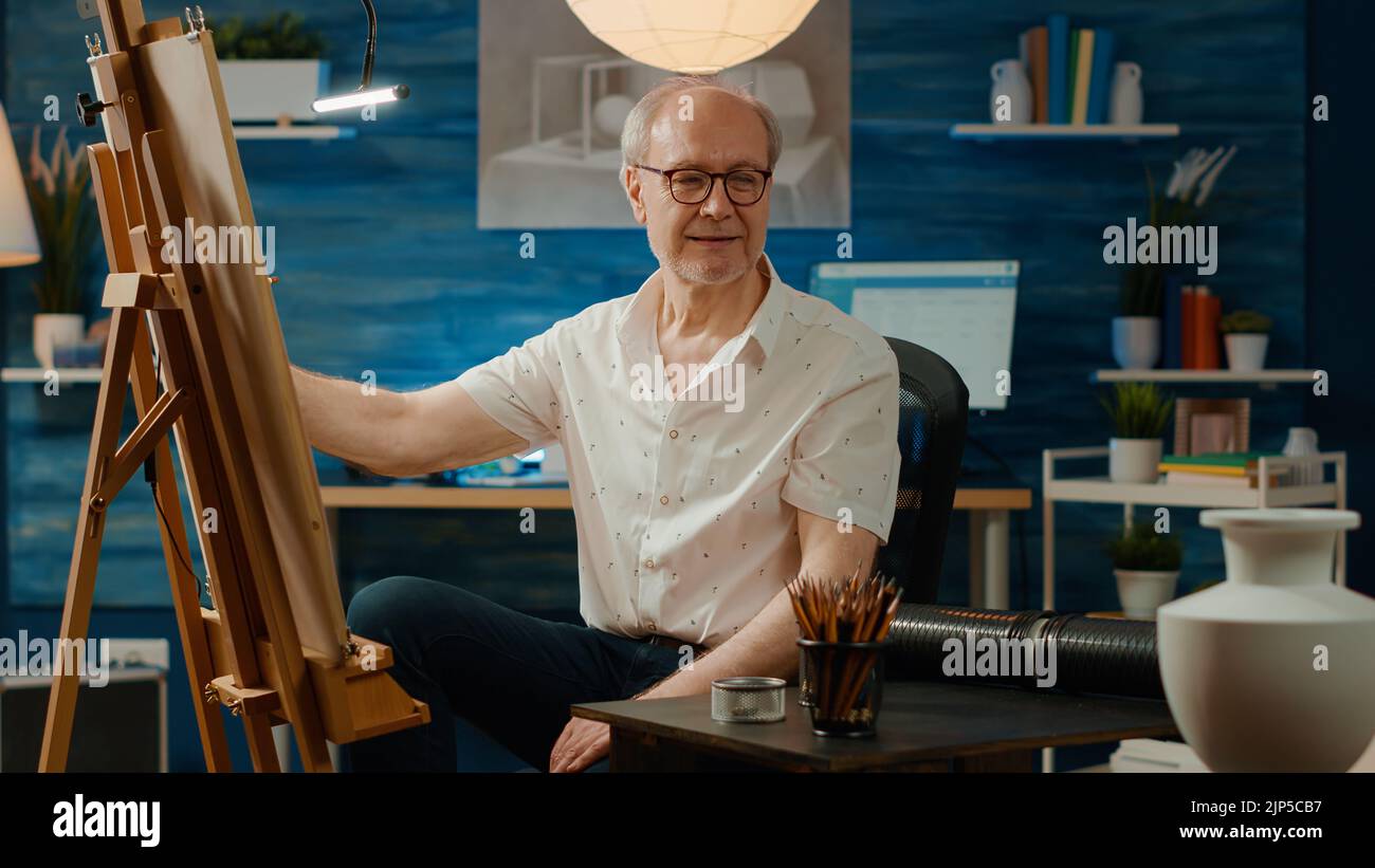 Senior man drawing vase model on canvas with artistic tools and skills