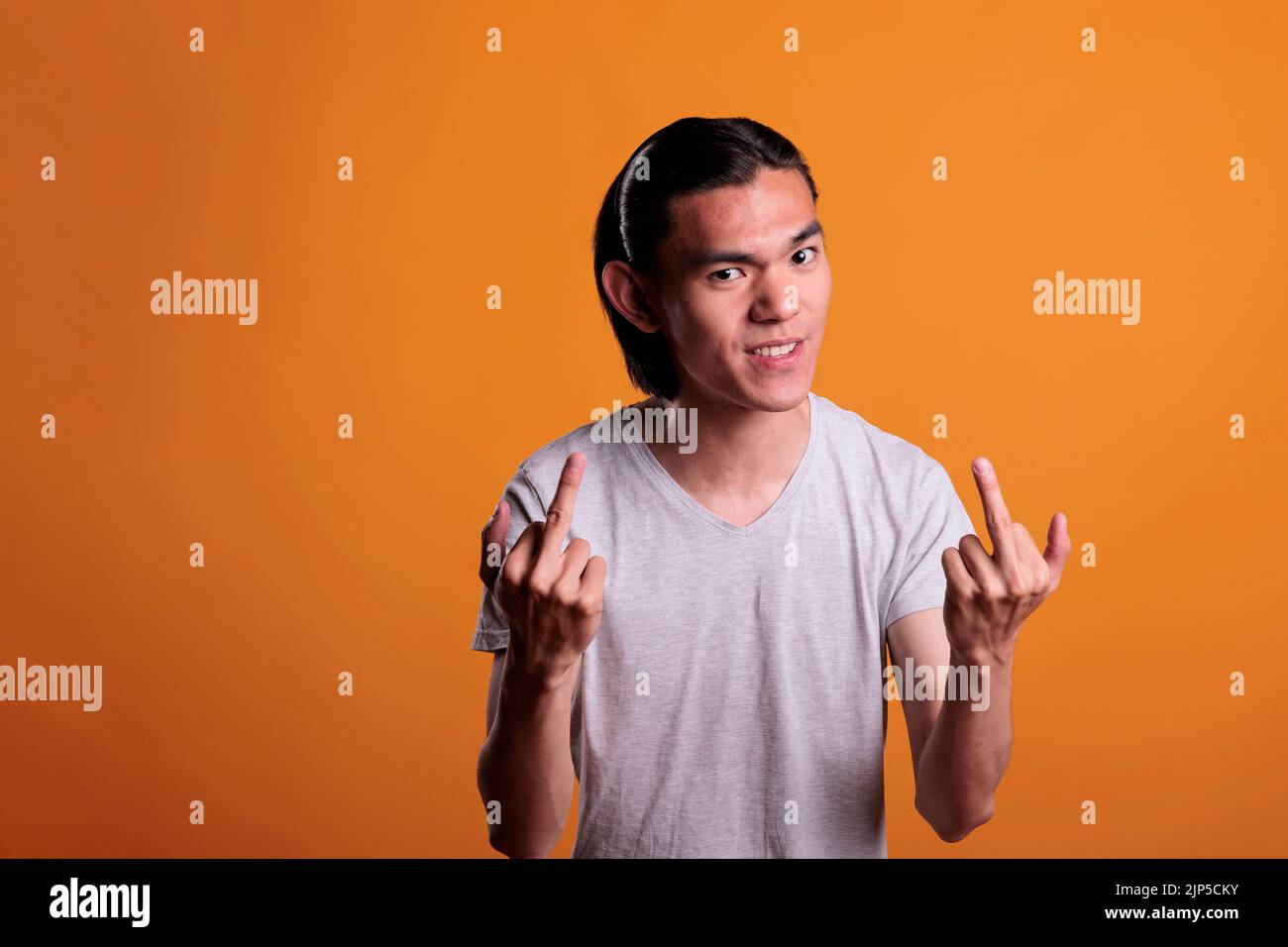 Angry young asian man showing middle fingers, offensive provocative ...