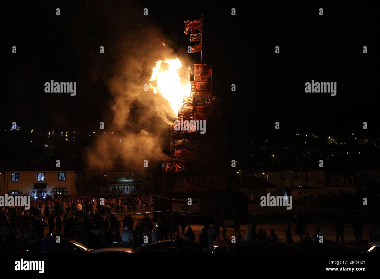 People gather at the burning of a bonfire to mark the Catholic Feast of the Assumption in the Bogside area of Londonderry, Northern Ireland. Picture date: Monday August 15, 2022. Stock Photo