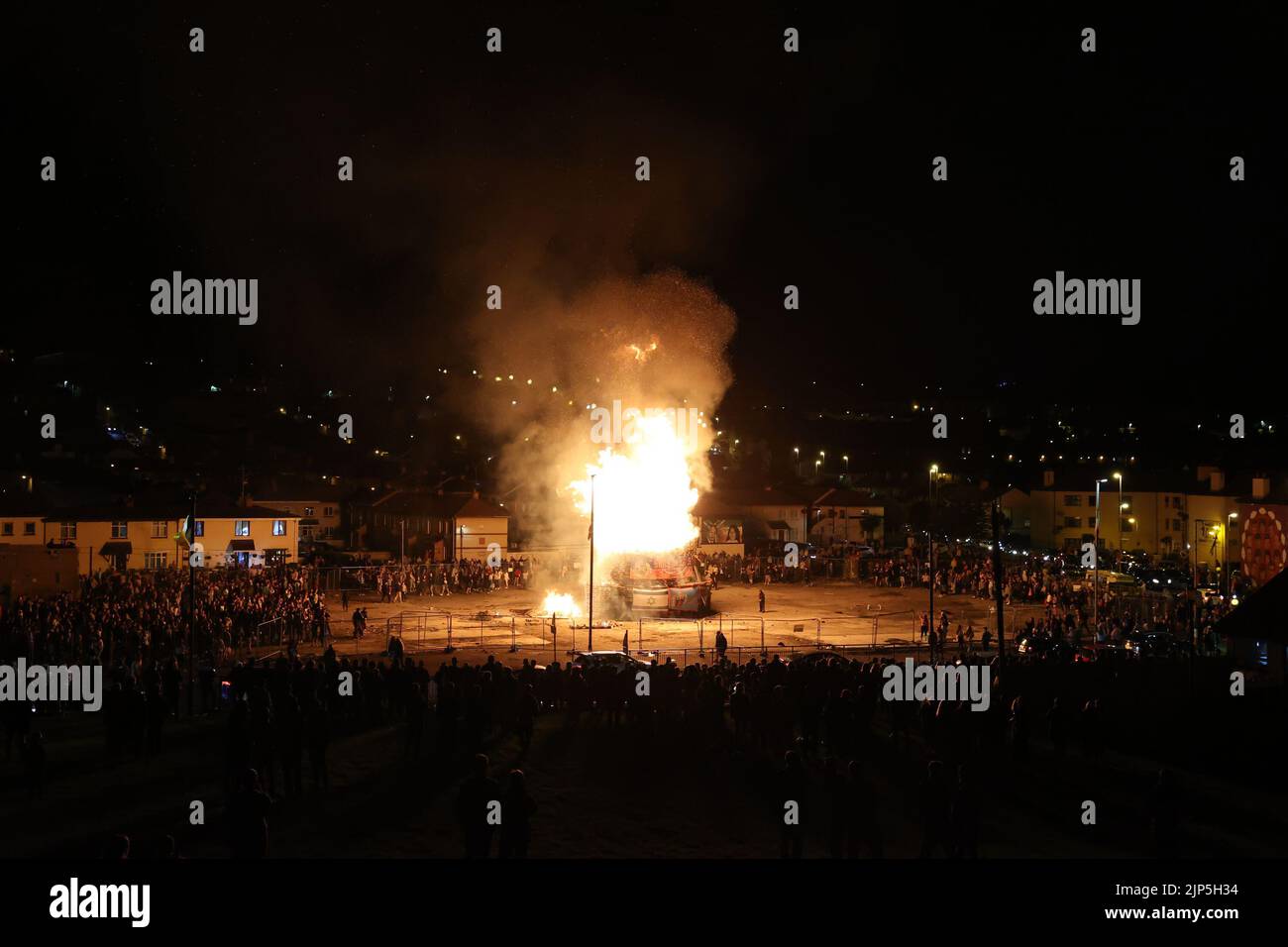 People gather at the burning of a bonfire to mark the Catholic Feast of the Assumption in the Bogside area of Londonderry, Northern Ireland. Picture date: Monday August 15, 2022. Stock Photo