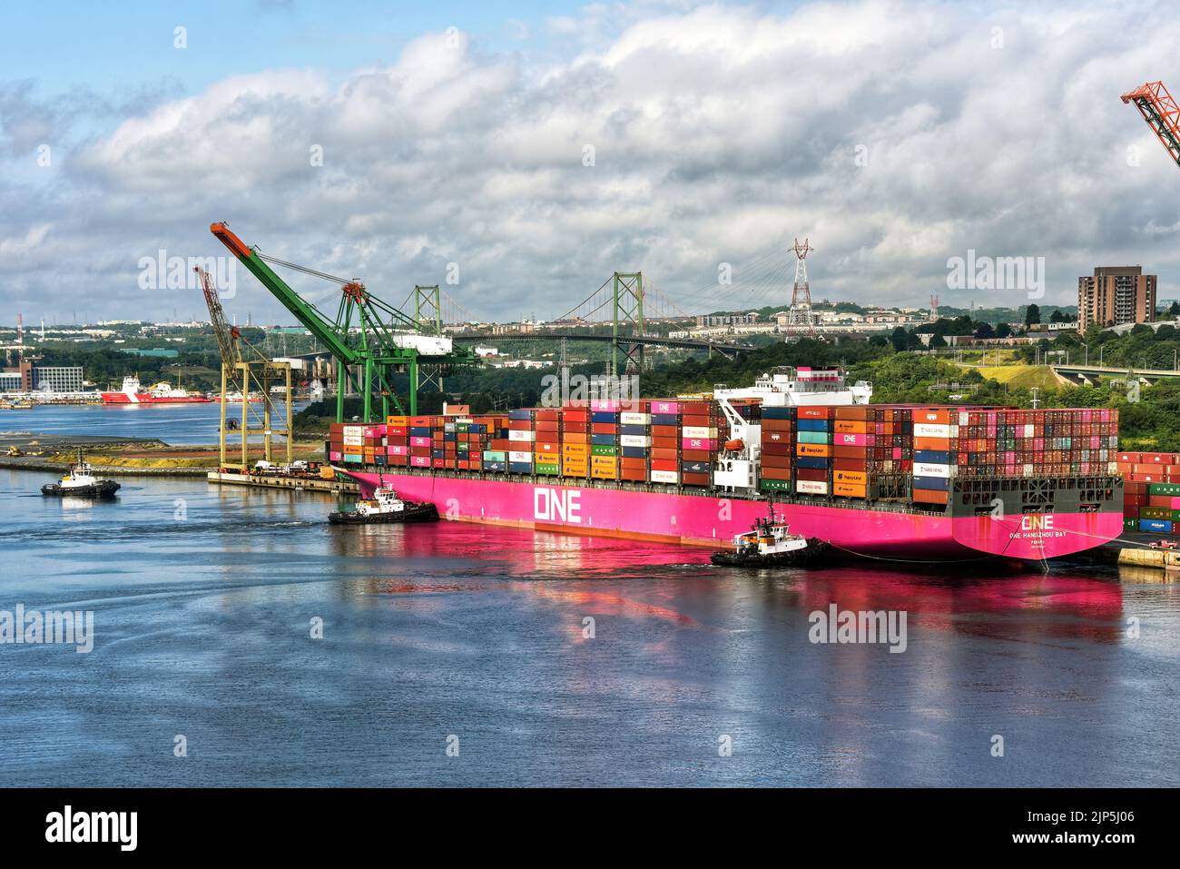 Halifax, Canada - July 30, 2022: Tugboats assist the One Hangzhou Bay container ship as it leaves the Fairview Cove Container Terminal in the Bedford Stock Photo