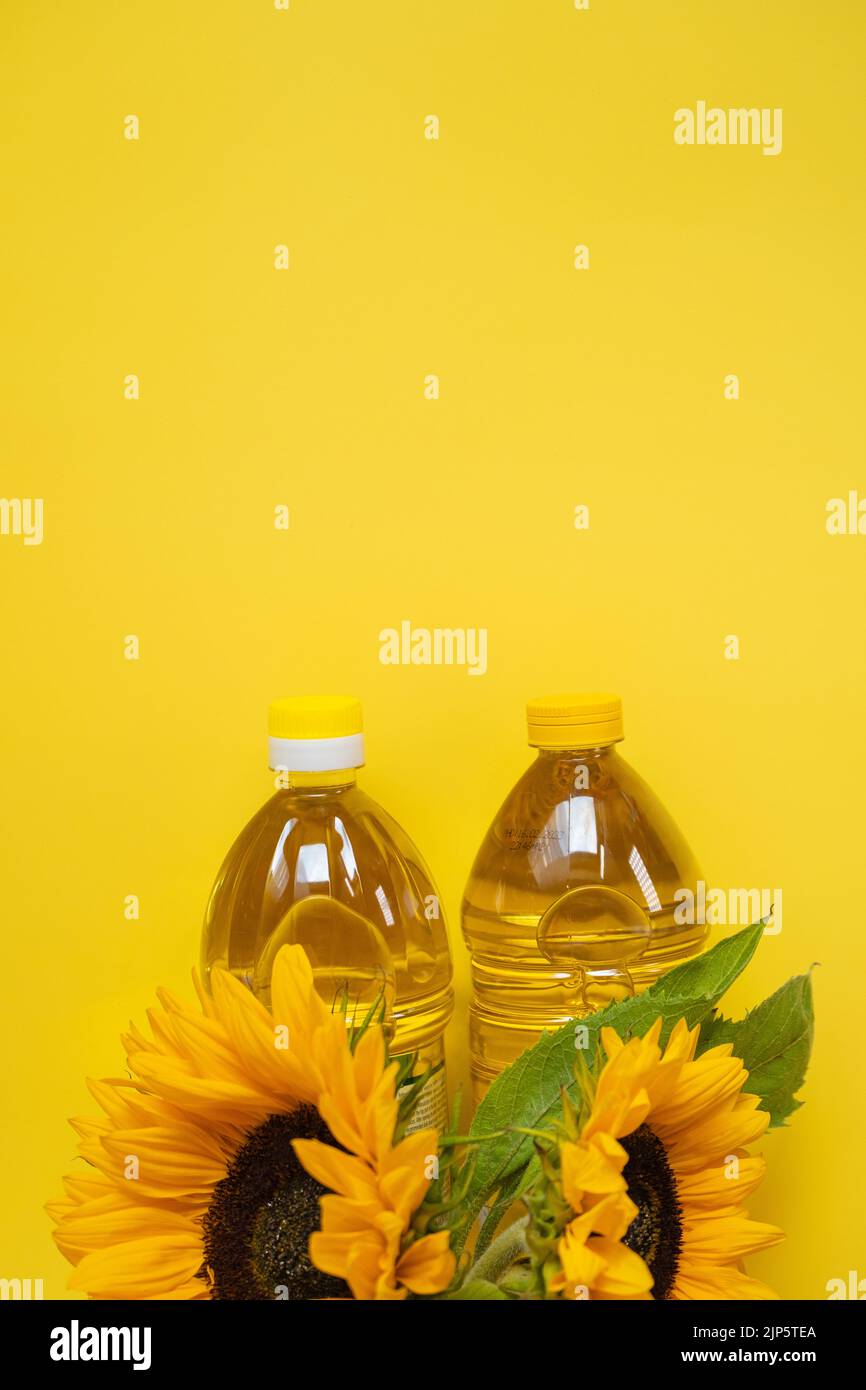 Sunflower oil. Oil bottles and sunflowers on a yellow background