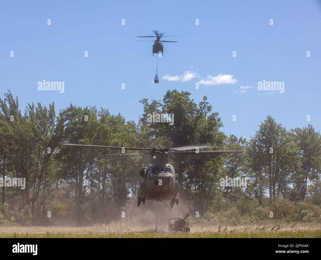 A U.S. Army CH-47 Chinook, assigned to 1st General Support Aviation Battalion, 111th Aviation Regiment, prepares to lift an M119A3 Howitzer during Operation Northern Strike at Camp Grayling, Mich., Aug. 11, 2022. Northern Strike is a readiness operation that maintains, improves and exceeds directed training levels by providing a venue for units to maximize proficiencies and help validate training. Stock Photo