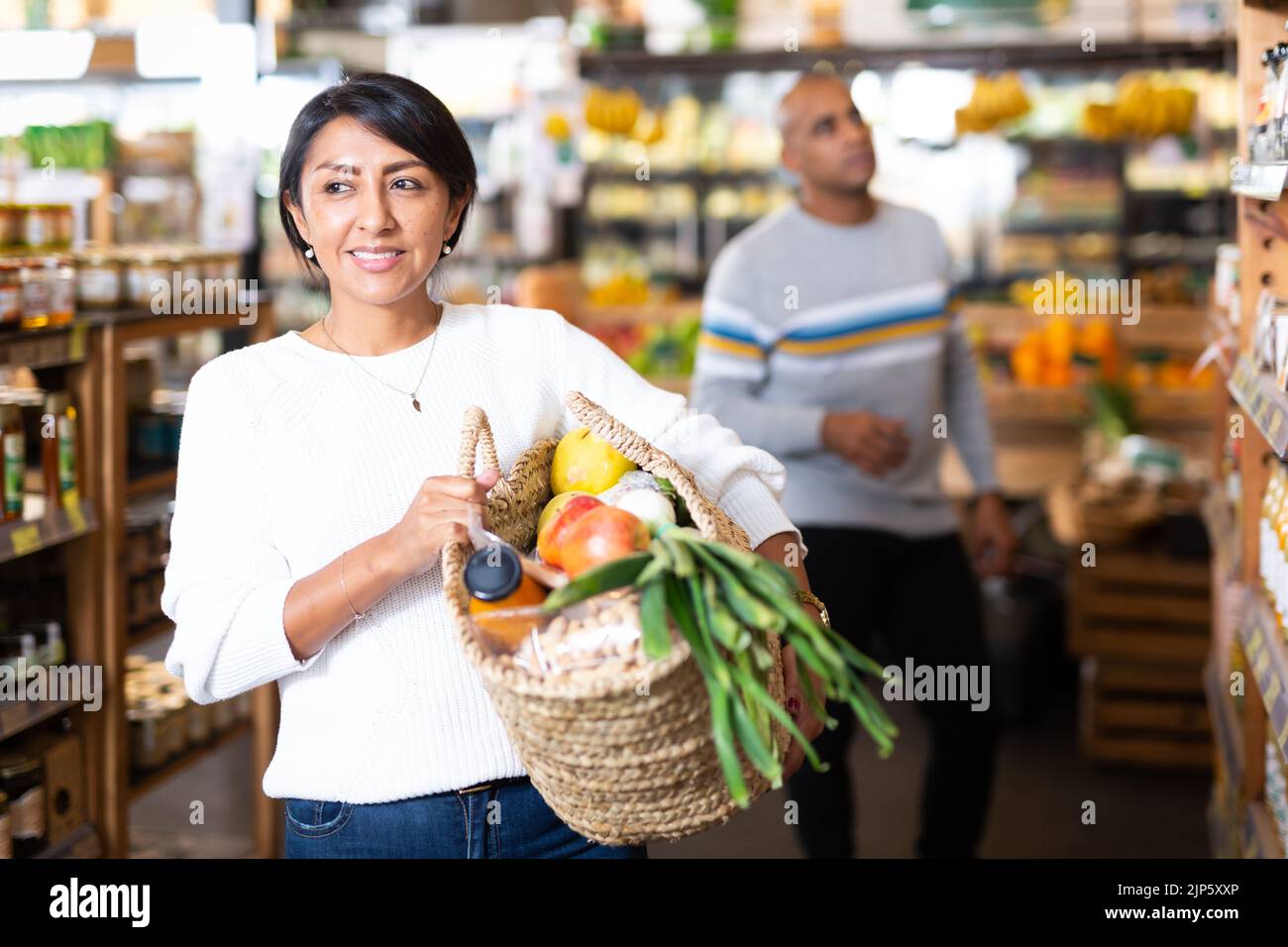 Smiling Latin American Woman Enjoying Shopping In Grocery Store Stock Smiling Latin American Woman Enjoying Shopping In Grocery Store Stock