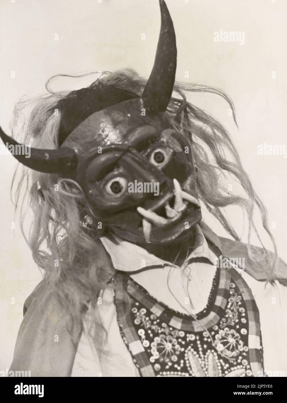 Black and white photograph of  Devil dancer mask used in the  Festival of the Virgin of Carmen that takes place in the Peruvian town of Paucartambo every July, Peru, South America Stock Photo