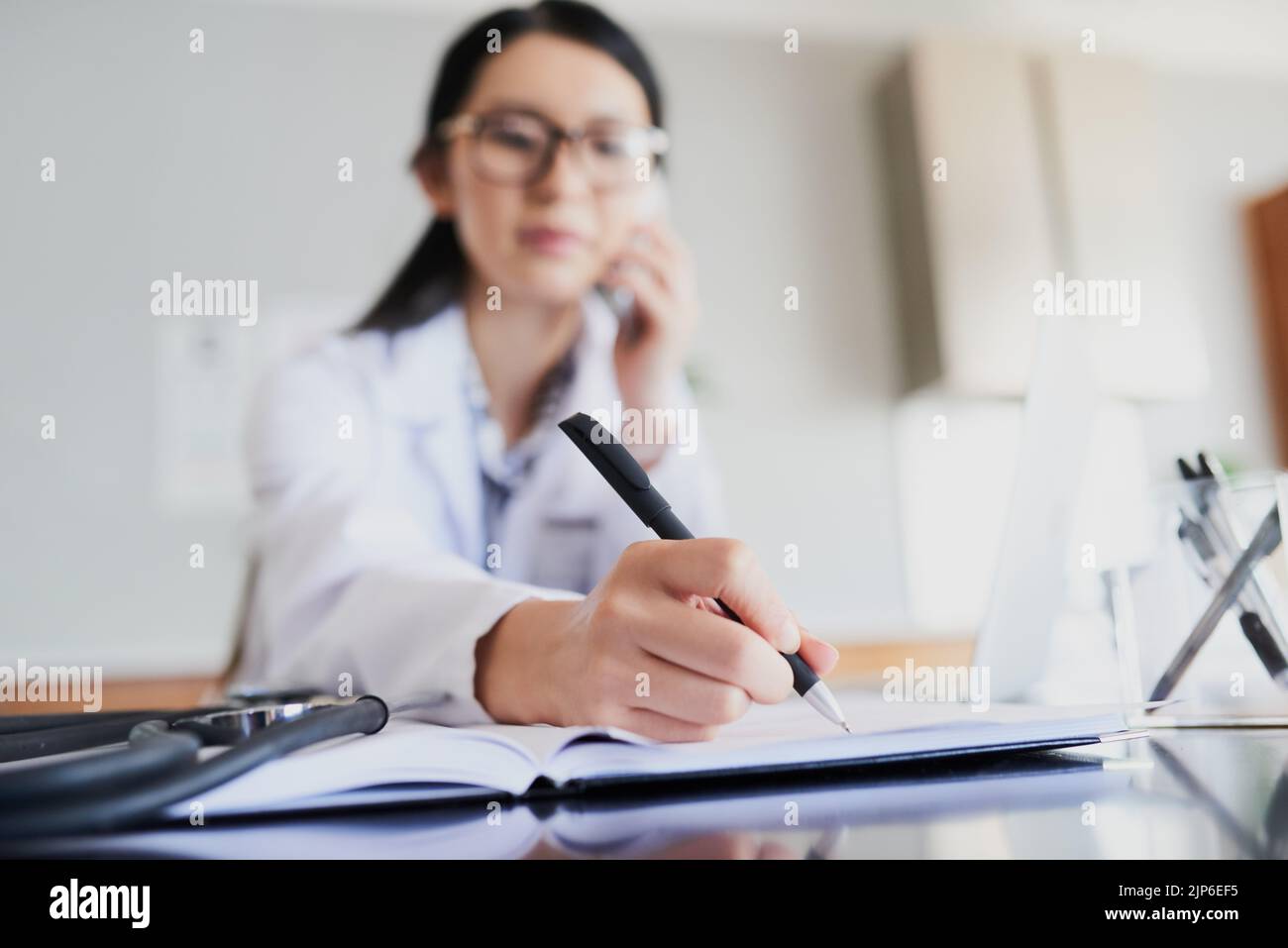 Ive got an open space later today... a young female doctor making notes while working in a hospital. Stock Photo