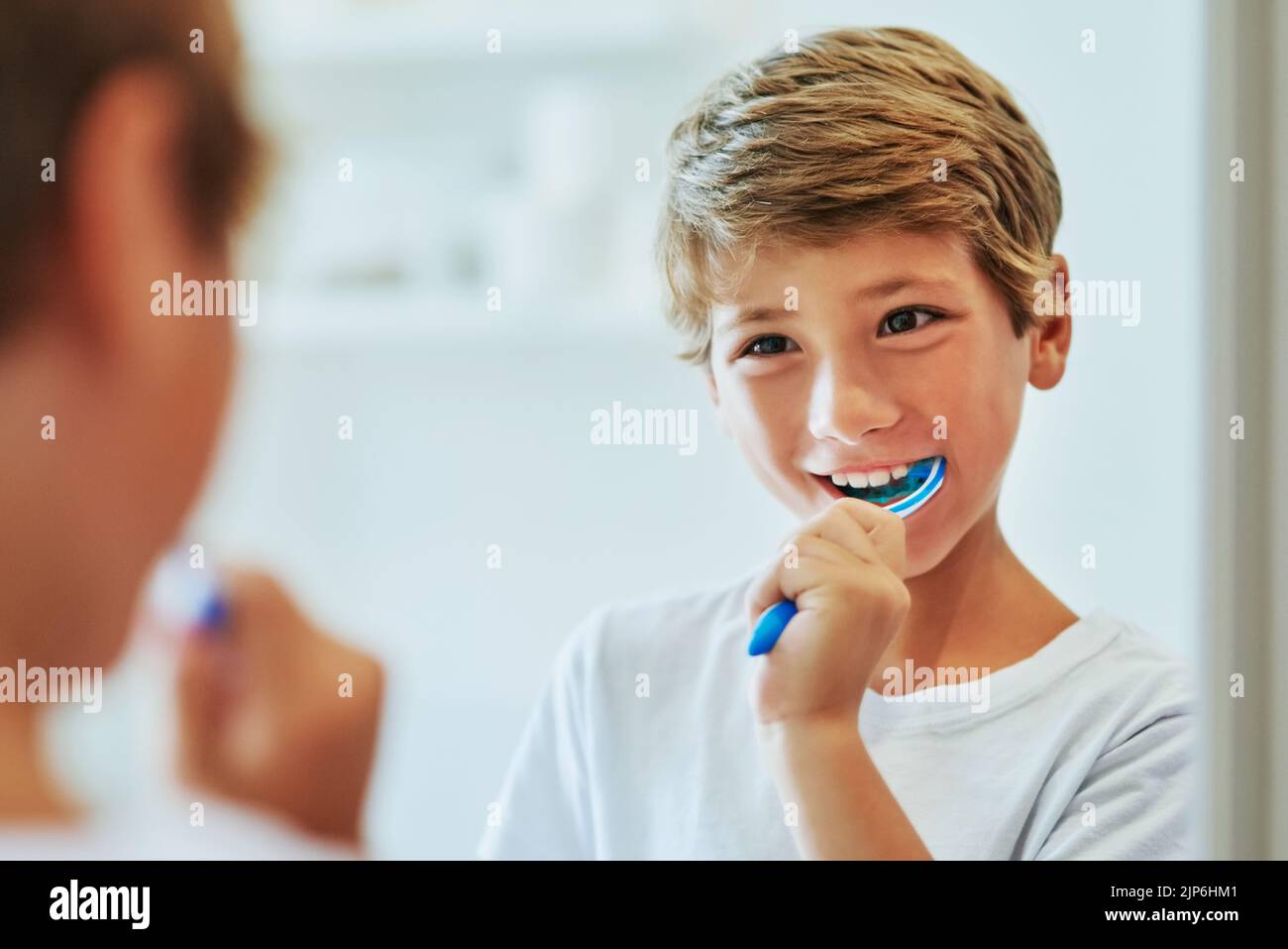Got to brush those teeth in the morning. a cheerful young boy looking ...