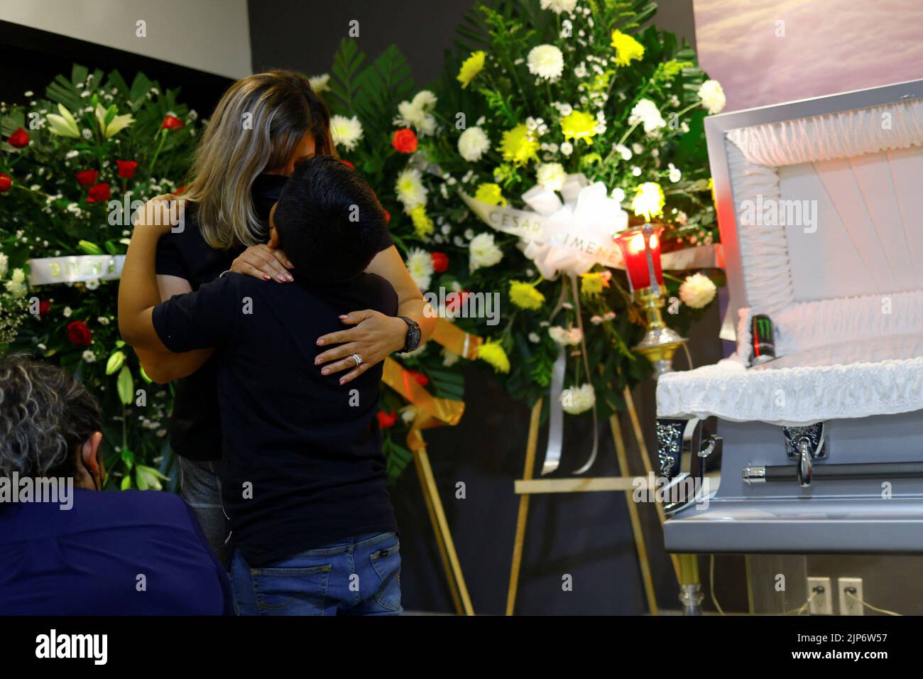 Alejandro Arriaga, son of Manuel Alejandro Arriaga, who was killed last week along with three coworkers of Switch radio station, is hugged by his mother Viviana Guapo in front of Arriaga´s coffin during the funeral, in Ciudad Juarez, Mexico, August 15, 2022. REUTERS/Jose Luis Gonzalez Stock Photo