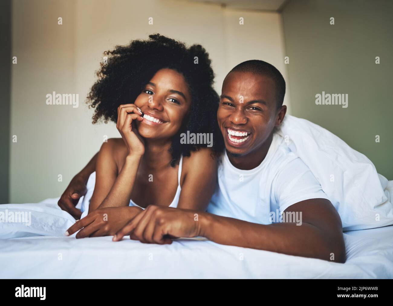 Morning time is our quality time. Portrait of a happy young couple relaxing under a duvet in their bedroom. Stock Photo
