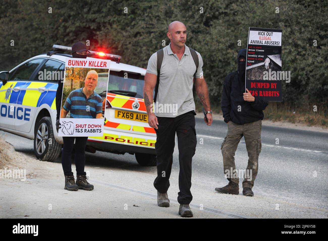 A worker walks past police and animal rights activists during the ...