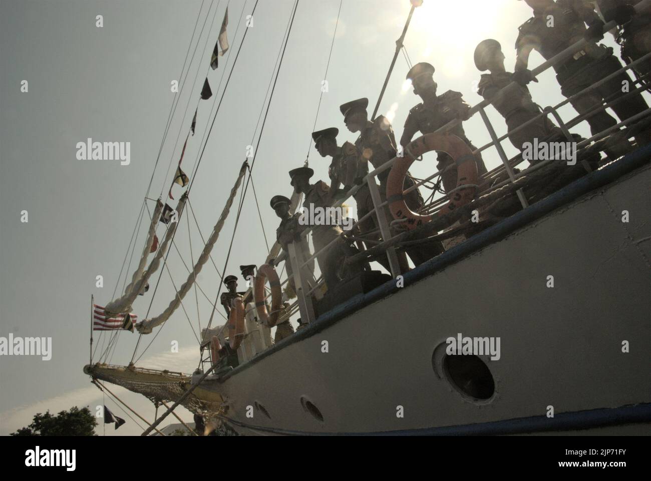 Indonesian navy officers are photographed against a bright sunlight as they are standing on the deck of KRI Dewaruci (Dewa Ruci), an Indonesian tall ship, after the barquentine type schooner is opened for public visitors at Kolinlamil harbour (Navy harbour) in Tanjung Priok, North Jakarta, Jakarta, Indonesia. Stock Photo