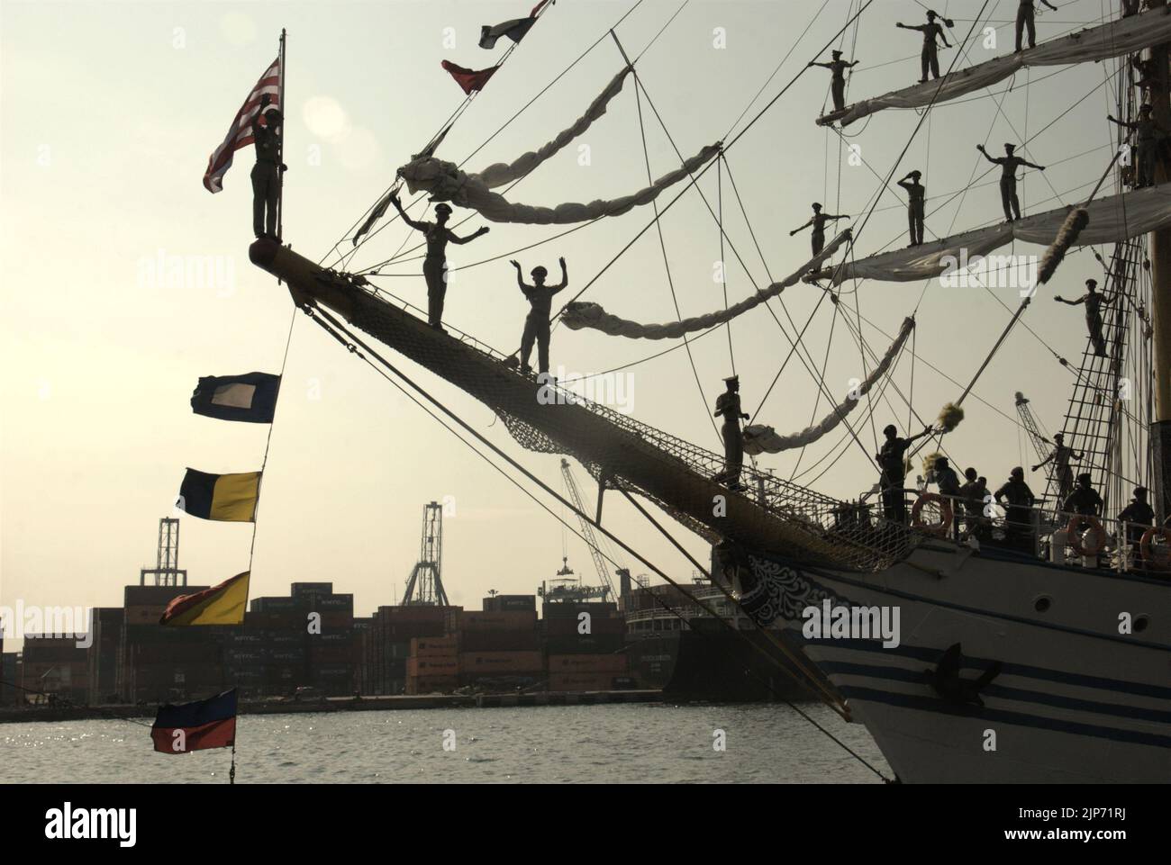 Indonesian navy cadets waving goodbye as KRI Dewaruci (Dewa Ruci), an Indonesian tall ship, is setting up a sail after the barquentine type schooner being opened for public visitors at Kolinlamil harbour (Navy harbour) in Tanjung Priok, North Jakarta, Jakarta, Indonesia. Stock Photo