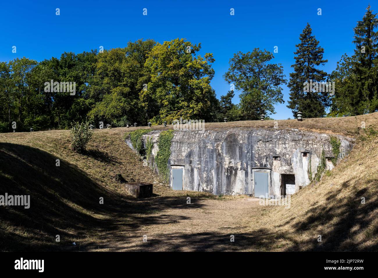 10 August 2022, France, Mutzig: The entrance doors of a bunker can be seen between overgrown hills. The 'Feste Kaiser Wilhelm II' complex with underground barracks and corridors, built from 1893 during the German Empire, is to be sold by the French military to the local community association. The latter wants to improve the hitherto provisional facilities for visitors. A local association is responsible for visitor care - but after the Corona crisis, guests from neighboring Germany are staying away. (to dpa 'Association wants more visitors from Germany at the Kaiser Fort') Photo: Philipp Stock Photo