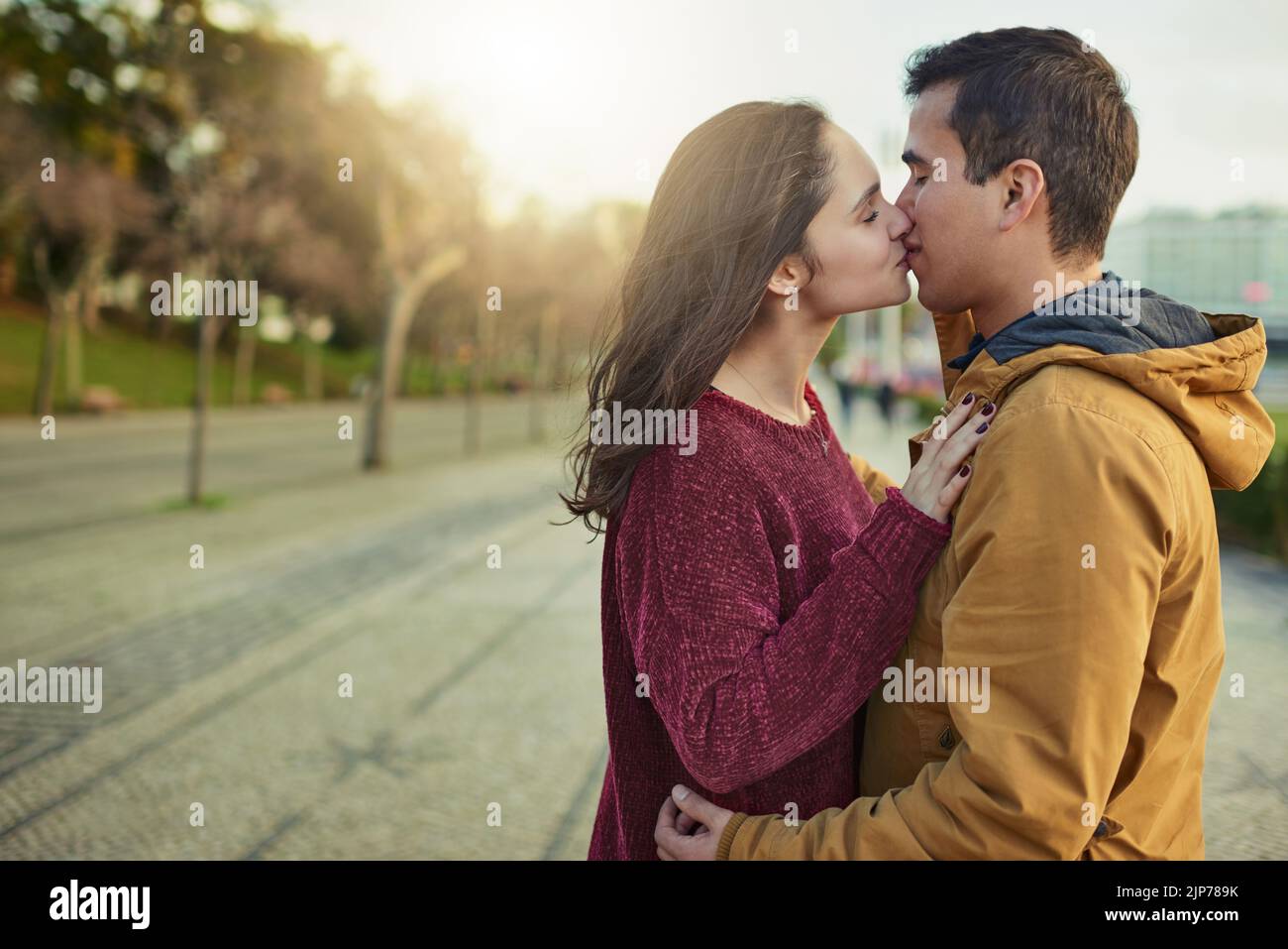 Those I want you forever kisses. a happy young couple kissing each other outdoors. Stock Photo