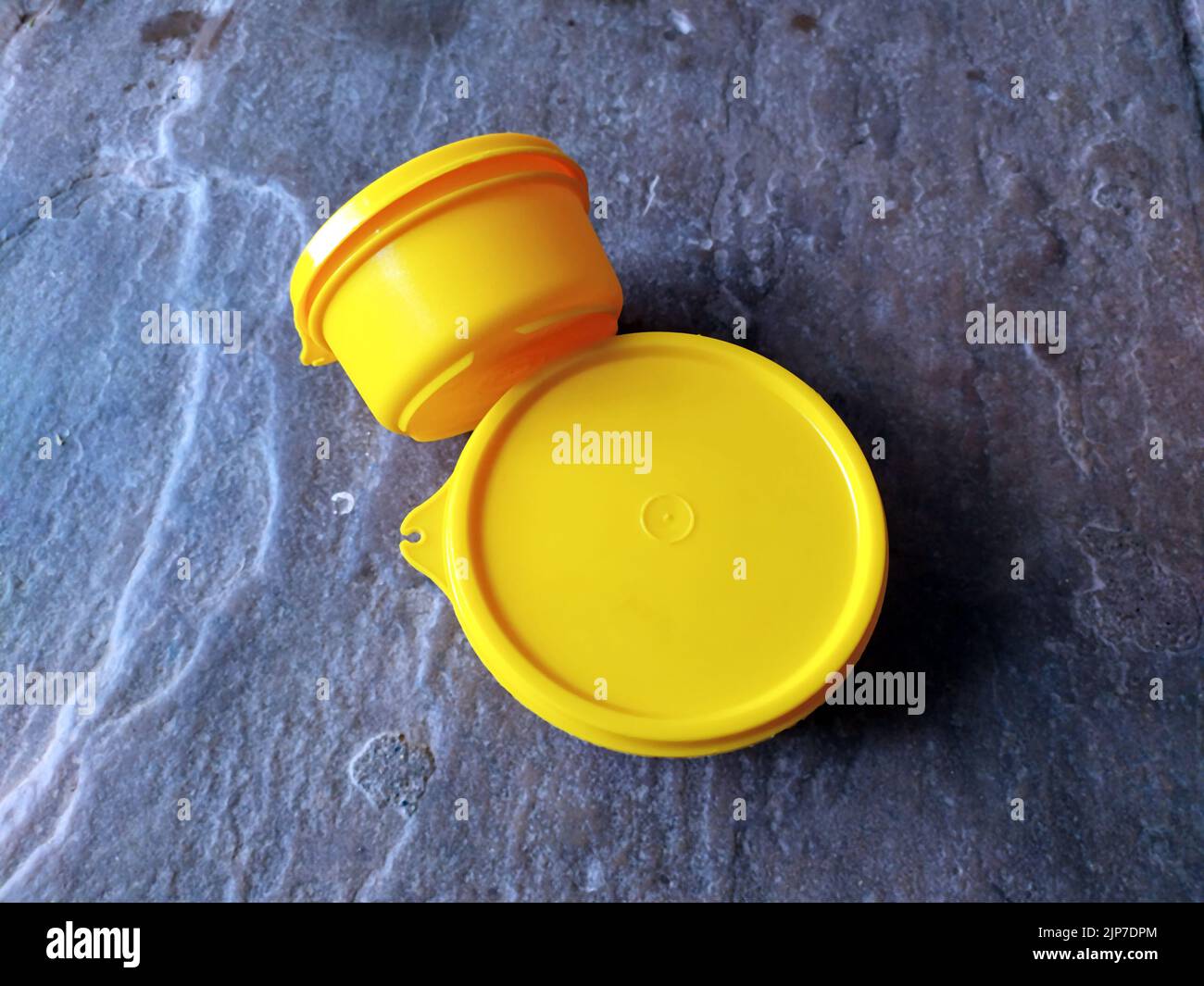 yellow plastic container box on stone background Stock Photo Alamy