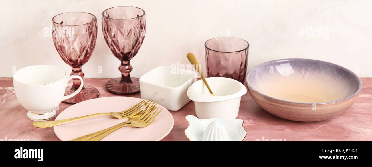 Set of clean dinnerware on pink table against light background Stock ...