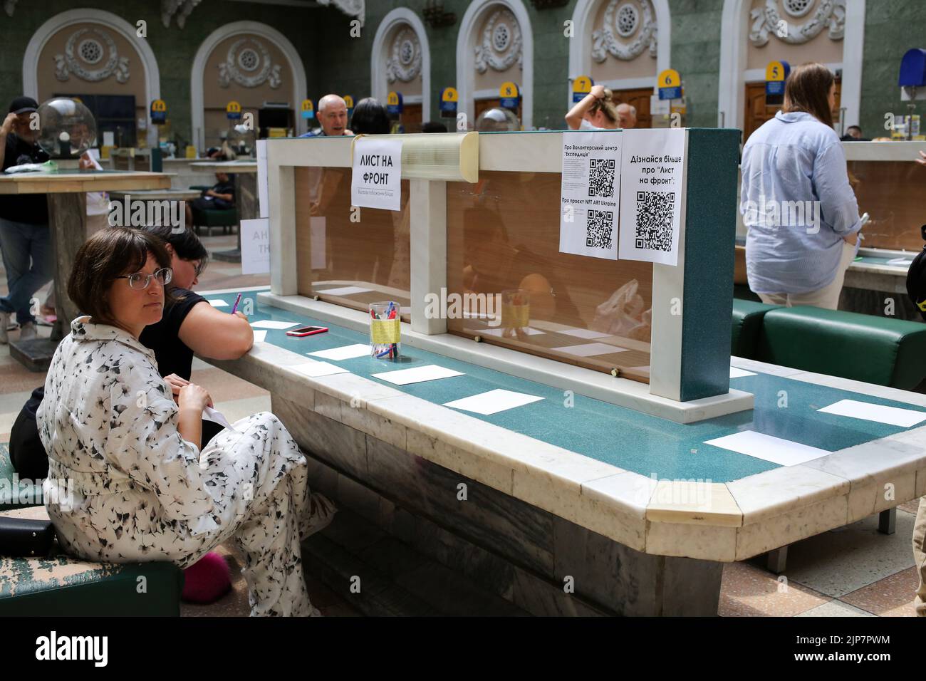 Odessa, Ukraine. 12th Aug, 2022. A woman seen writing a letter to the front. Letter to the front. Project from Ukrpochta (Ukrainian Post).Every large and small Ukrainian can express his gratitude to the modern heroes by sending a picture or a postcard to any branch of Ukrposhta. All children's drawings and postcards with words of support and hope for a peaceful life from adults and children will be given to military personnel in hot spots, as well as to medics and rescuers, representatives of ground defense, and communal services throughout the country. (Credit Image: © Viacheslav Onyshchenko Stock Photo