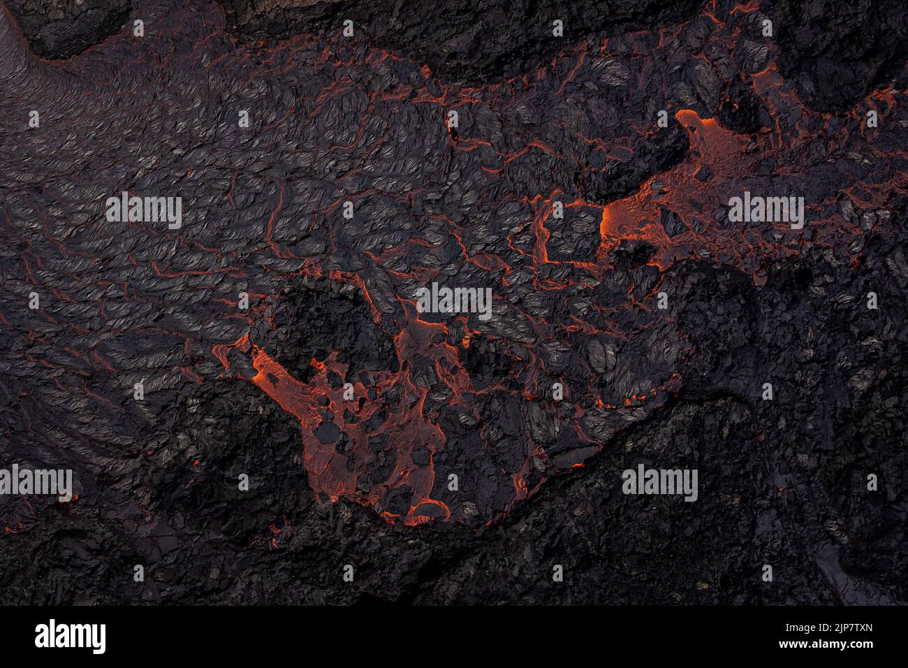 Magma flows from a heart shaped crater from the volcano in ...