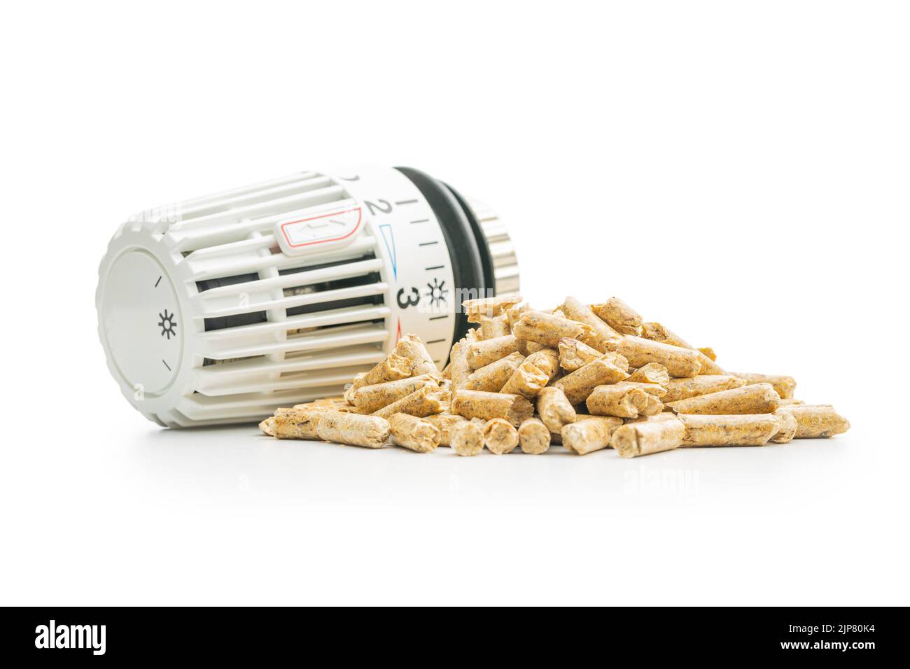 Wooden pellets and thermostatic valve head isolated on a white background. Biomass - Renewable source of heating. Stock Photo