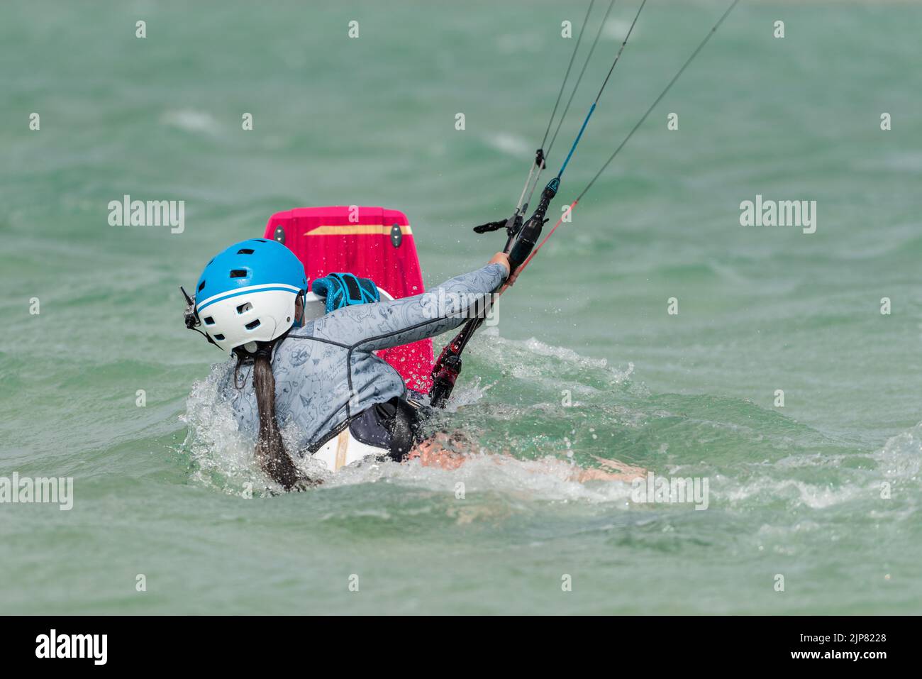 Woman learning kitesurfing, body dragging, girl at kiteboarding school