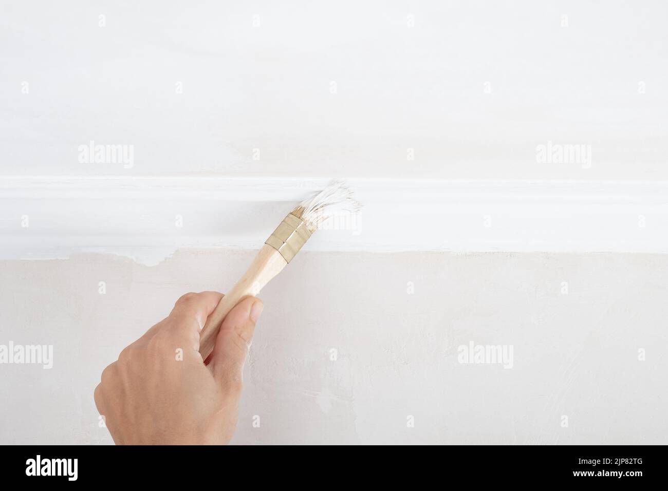 hand painting skirting boards white with a brush Stock Photo Alamy