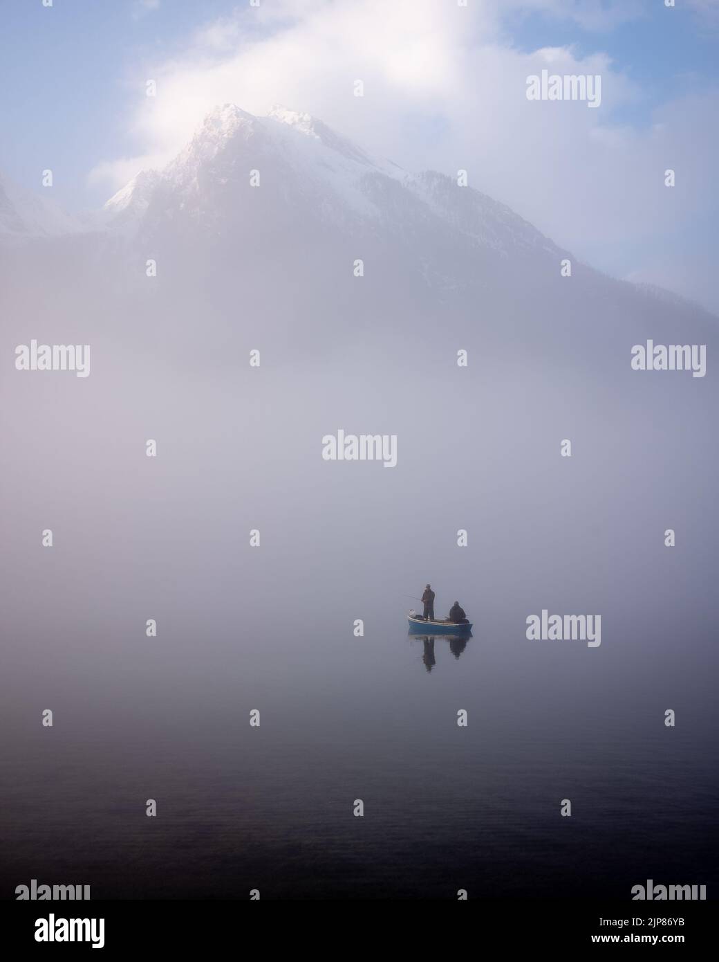 Two men fishing on foggy Hintersee in Bavarian Alps. Stock Photo