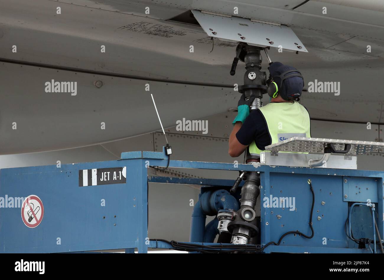 12 August 2022, Brandenburg, Schönefeld: A ground staff member refuels an Airbus A330-300 aircraft of the airline before the first flight of the Chinese airline Hainan from BER, at Berlin Brandenburg Airport. Photo: Wolfgang Kumm/dpa Stock Photo