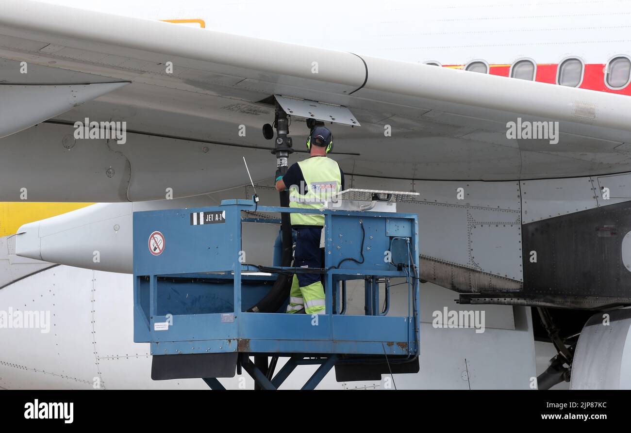 12 August 2022, Brandenburg, Schönefeld: A ground staff member refuels an Airbus A330-300 aircraft of the airline before the first flight of the Chinese airline Hainan from BER, at Berlin Brandenburg Airport. Photo: Wolfgang Kumm/dpa Stock Photo