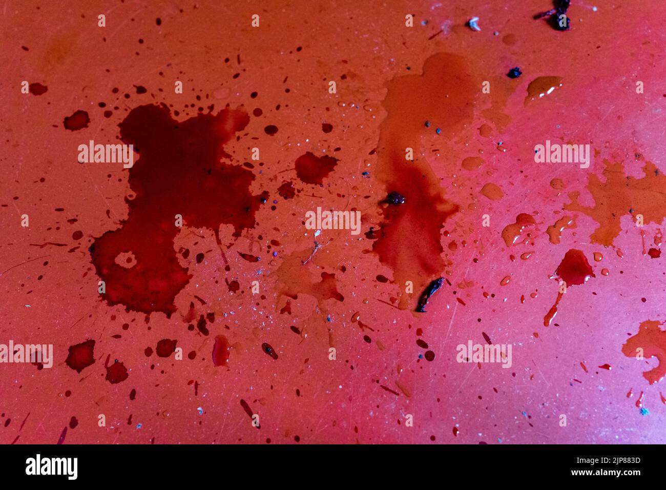 Spilled dark red liquid on red floor. Stock Photo