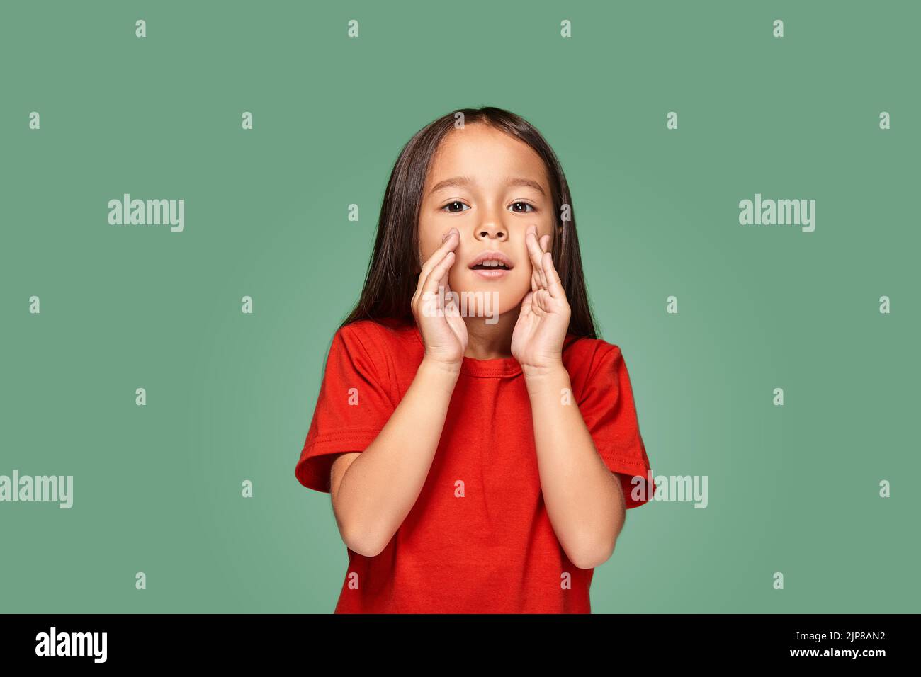 Portrait of a small pretty girl standing straight and calling someone ...