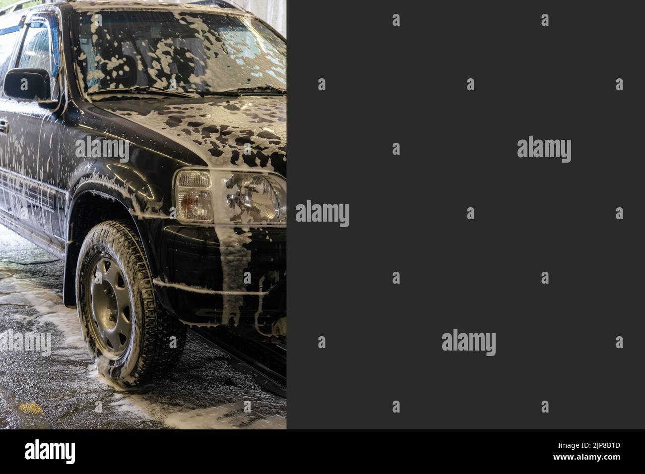 Washing black car with active foam, a copy space, banner. The car is serviced at the sink. Car wash self-service. Removal of dirt on the car. Stock Photo