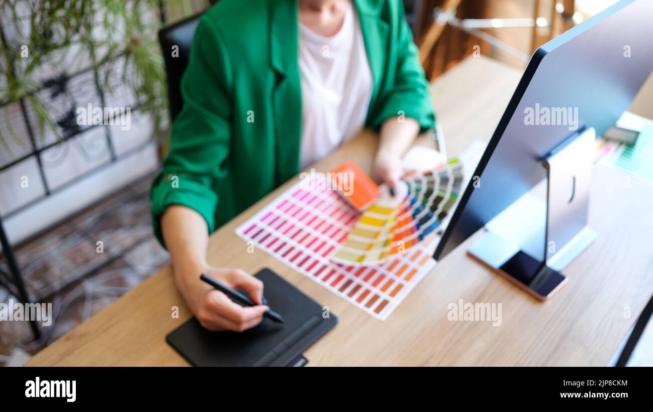 Woman interior designer working with fan of colourful samples in office Stock Photo