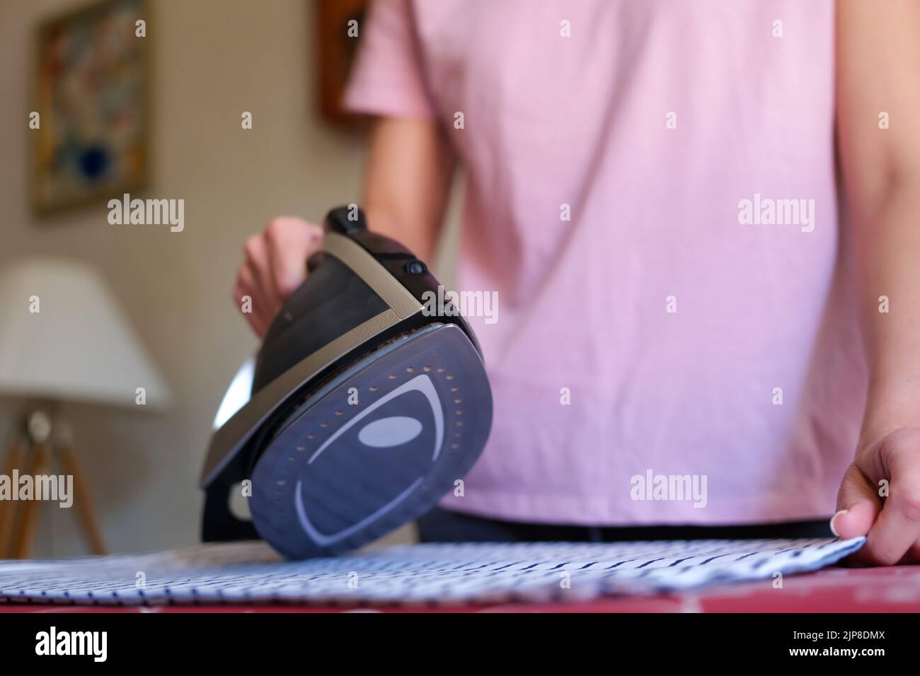 Woman housewife ironing bed linen using steam iron Stock Photo Alamy