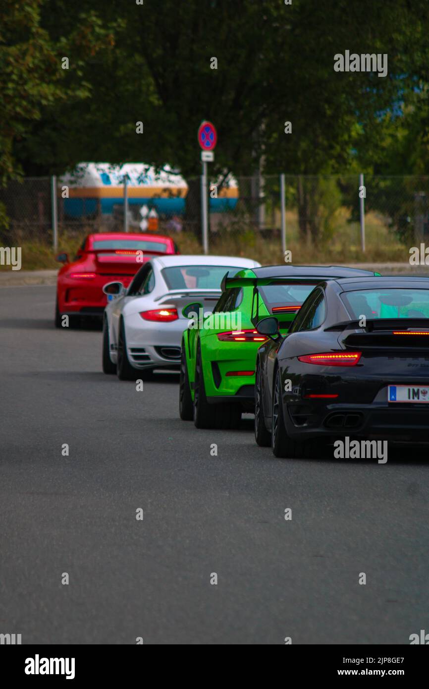A vertical shot of Porsche, Lamborghini Huracan on an asphalt road in ...