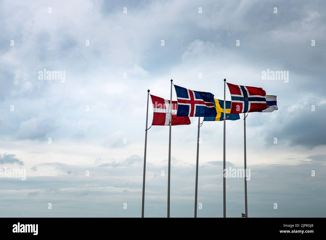 Scandinavian flags fluttering in the sky reminds of the historical Kalmar union between Sweden, Denmark, Iceland, Faroe Islands, Greenland and Norway Stock Photo