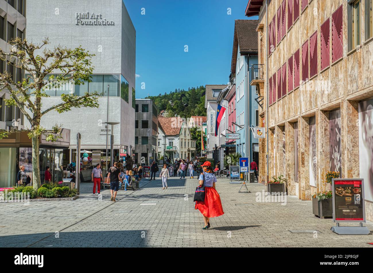 Vaduz main street (Stadtle) on a summer, sunny day. People walk outdoor in spring clothes by the Hilti Art Foundation in the city downtown district Stock Photo