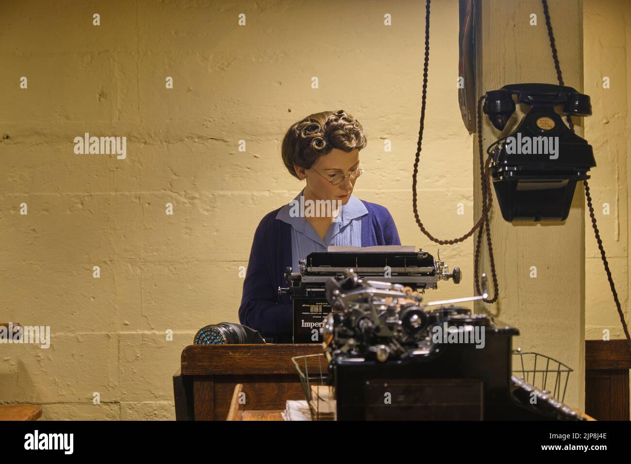 A woman busy typing in the typing pool area, room. At the Winston Churchill War Rooms Museum in London, England, United Kingdom. Stock Photo