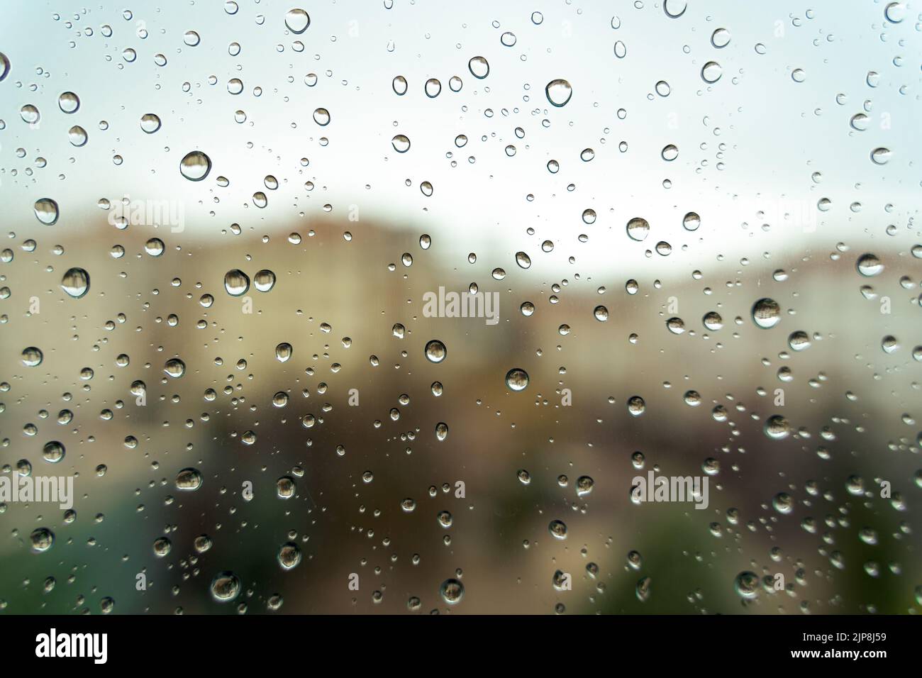 Raindrops on window, blurry background. Close-up view. Stock Photo
